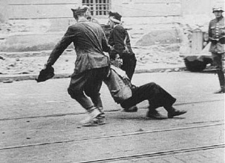 German soldier watches Ukrainian civilians drag a Jew down a street in Lvov